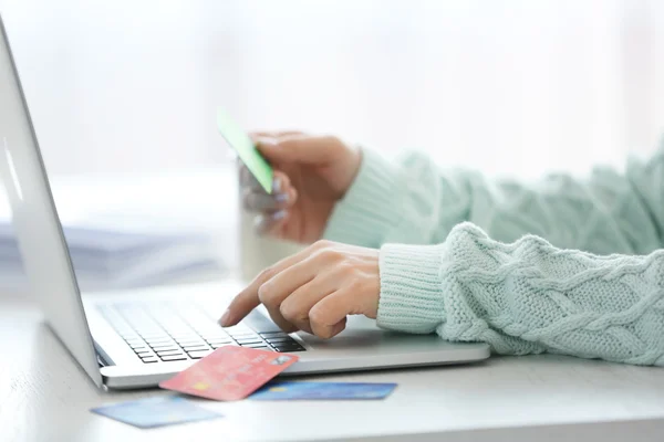 Concetto di commercio elettronico. Donna con carta di credito, laptop e tazza di caffè, primo piano — Foto Stock