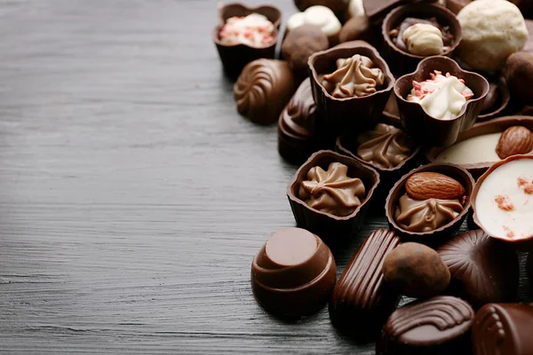 Köstliche Schokoladenbonbons auf hölzernem Hintergrund — Stockfoto