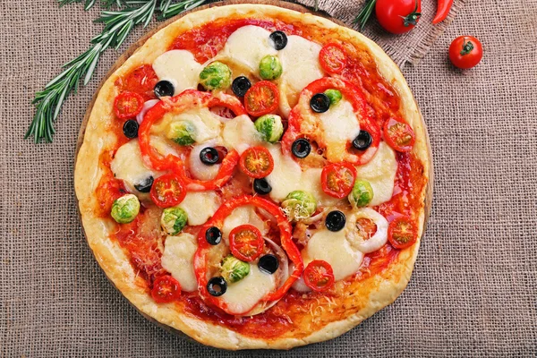 Deliciosa pizza con queso y verduras sobre fondo de saco —  Fotos de Stock