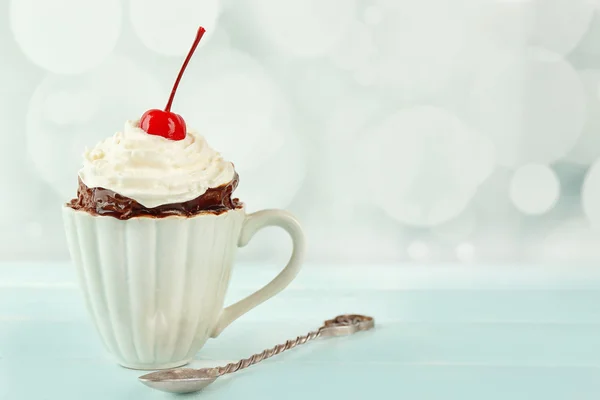 Ciasto czekoladowe kubek z cream i cherry na stole — Zdjęcie stockowe