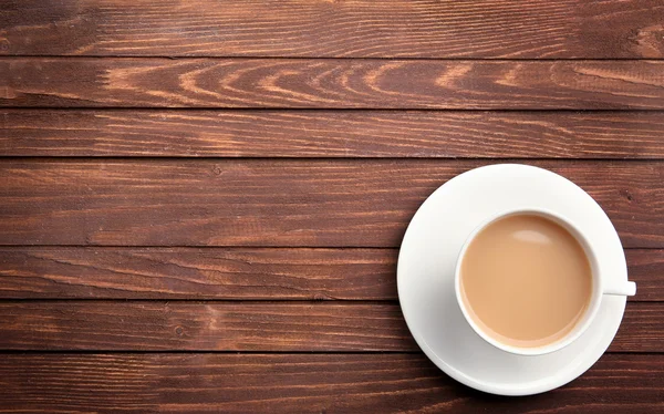 Porcelanowa filiżanka herbaty z mlekiem na drewniane tła — Zdjęcie stockowe