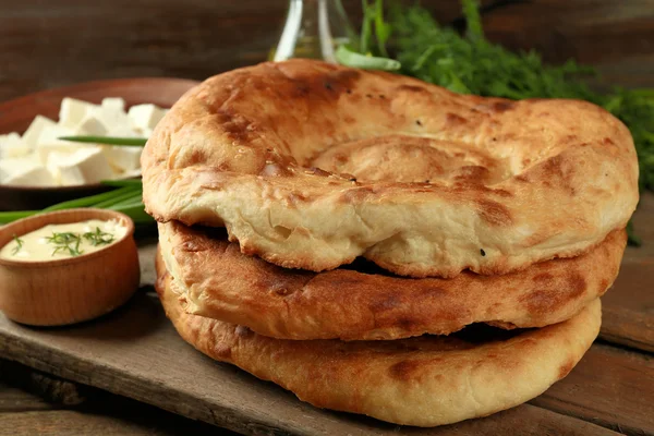 Fresh fried bread and other products on wooden table closeup — Stock Photo, Image