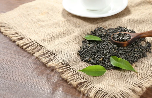 Torra te med gröna blad på säckväv bakgrund — Stockfoto
