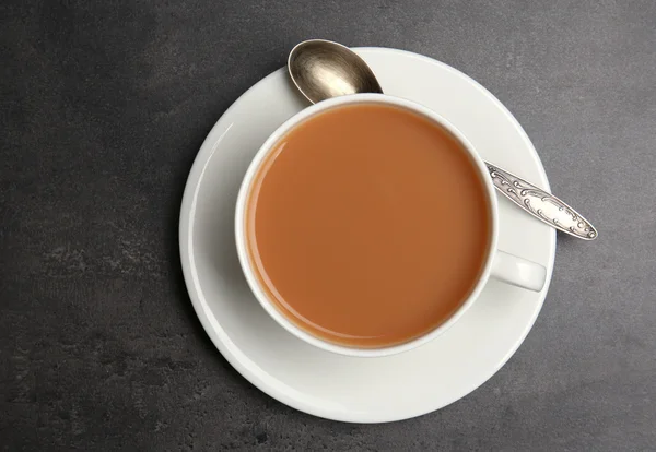 Porcellana tazza di tè con latte su sfondo grigio — Foto Stock