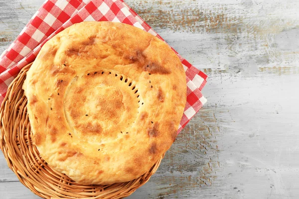 Flat bread in a wicker bowl on napkin, top view — Stock Photo, Image