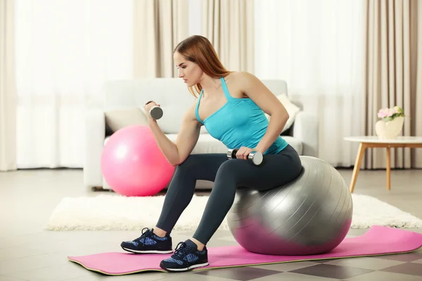 Sportswoman doing exercises with ball and dumbbells — Stock Photo, Image