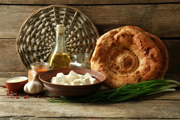 Fresh fried bread with other products on wooden background — Stock Photo, Image