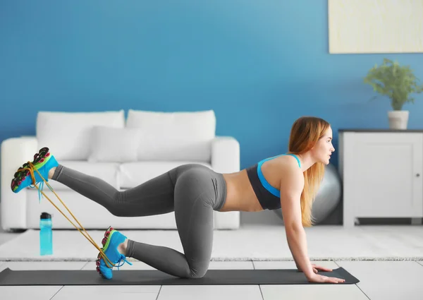 Sportswoman doing exercises with rubber band — Stock Photo, Image