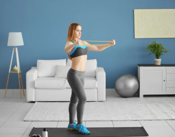 Sportswoman doing exercises with rubber band — Stock Photo, Image