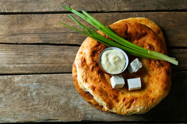 Pão frito fresco com cebolinha, molho e queijo em fundo de madeira — Fotografia de Stock