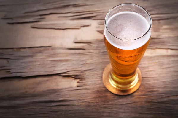 Glass of light beer on wooden background — Stock Photo, Image