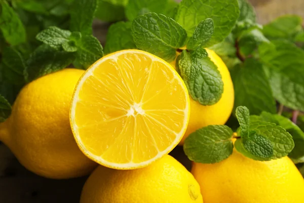 Limoni freschi affettati con foglie verdi primo piano — Foto Stock