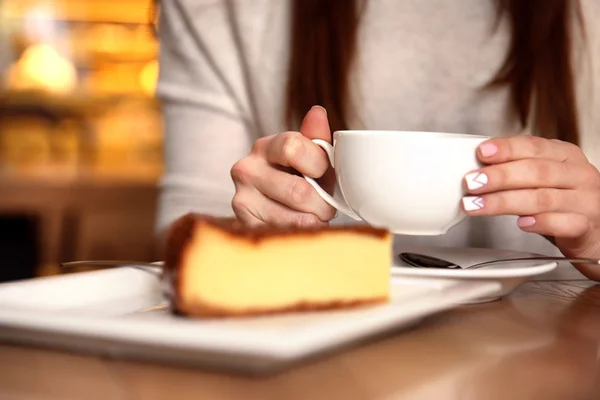 Tasty cheesecake and woman with tea — Stock Photo, Image