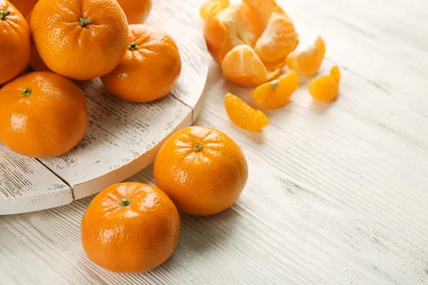 Deliciosas tangerinas e tangerinas com fatias na mesa de madeira, de perto — Fotografia de Stock