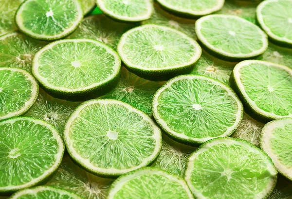 Green background of sliced lime — Stock Photo, Image