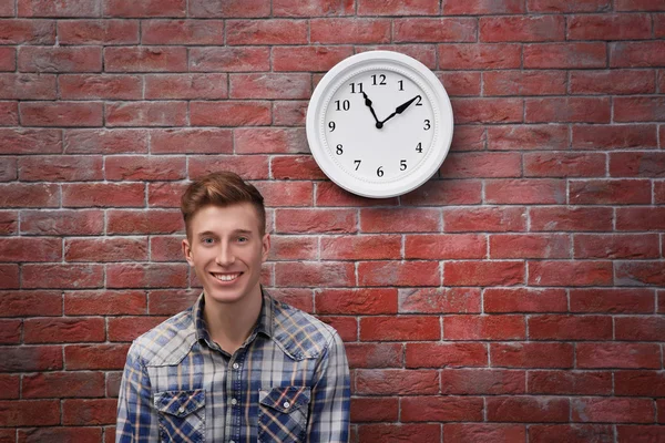 Man and clock on brick wall — Stock Photo, Image