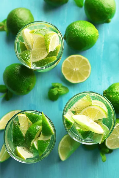 Bebidas mojito frescas con lima, limón y menta sobre fondo azul — Foto de Stock