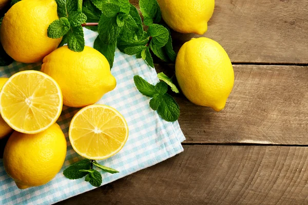 Sliced fresh lemons with green leaves on napkin closeup — Stock Photo, Image