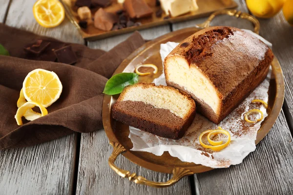 Composición de sabroso pastel con limón sobre fondo de madera gris — Foto de Stock