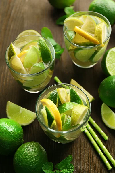 Bebidas mojito frescas com limão, limão e hortelã na mesa de madeira — Fotografia de Stock