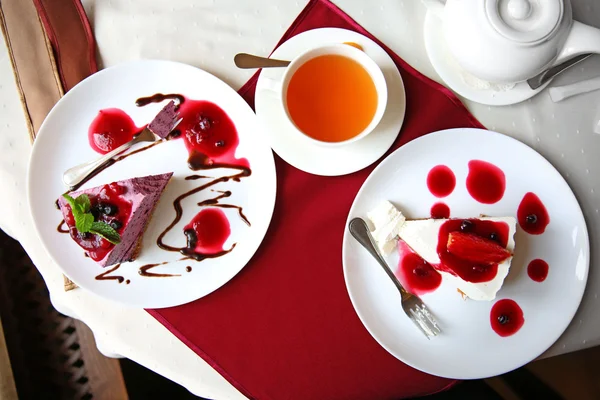 Gâteaux au fromage savoureux et tasse de thé sur la table dans un café ou un restaurant — Photo