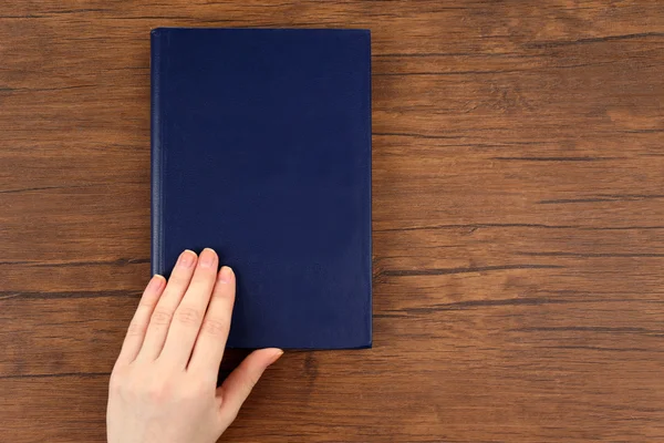 Mão feminina segurando um livro — Fotografia de Stock