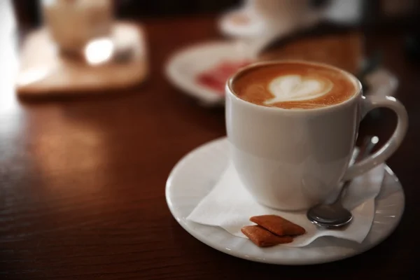 Šálek cappuccino na stole v kavárně — Stock fotografie