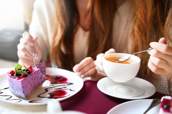 おいしいチーズケーキと紅茶のカップを持つ女性 — ストック写真