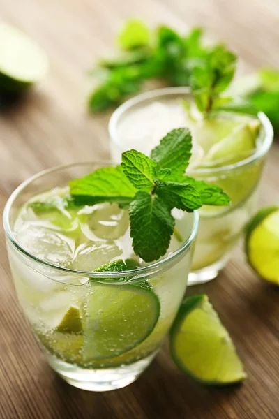 Mojito drink with lime and mint on wooden table — Stock Photo, Image