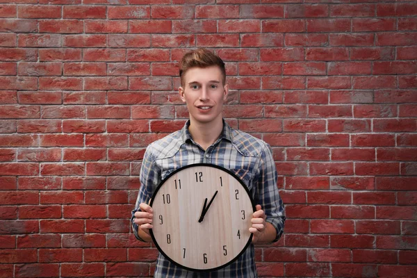 Man holding clock against wall — Stock Photo, Image