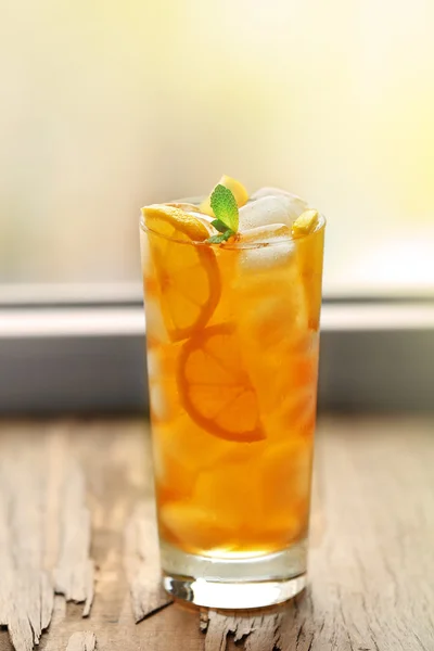 Vaso de té helado con limón en un alféizar de ventana — Foto de Stock