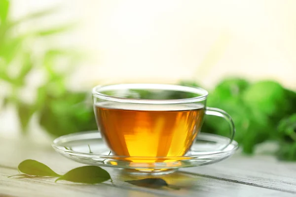 Чашка чая с мятой на деревянном столе — стоковое фото