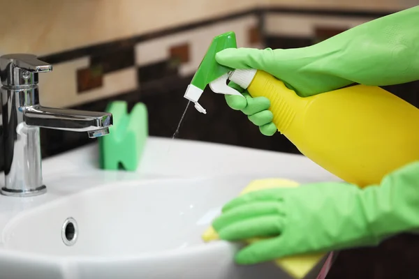 Vrouwelijke handen reinigen een wastafel — Stockfoto