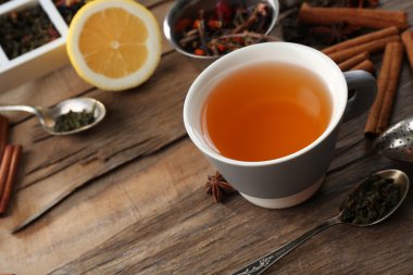 Baharatlar ve ahşap masa üzerinde limon ile demlenmiş çay