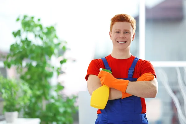 Junger Hausmeister mit flüssigem Waschmittel — Stockfoto