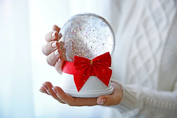 Mädchen hält Schneekugel in der Hand — Stockfoto