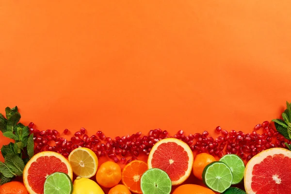 Conjunto de cítricos en rodajas con semillas de granada sobre fondo naranja — Foto de Stock