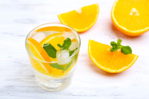 Färska cocktail med is, mint och orange på vita träbord bakgrund — Stockfoto
