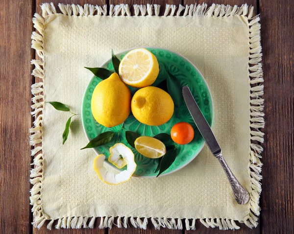 Fresh citrus fruits on a blue plate. — Stock Photo, Image