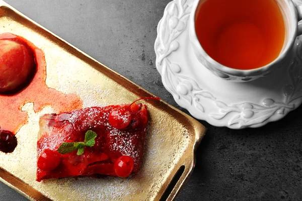 Cherry strudel met munt en kopje thee op gouden dienblad in poedervorm — Stockfoto