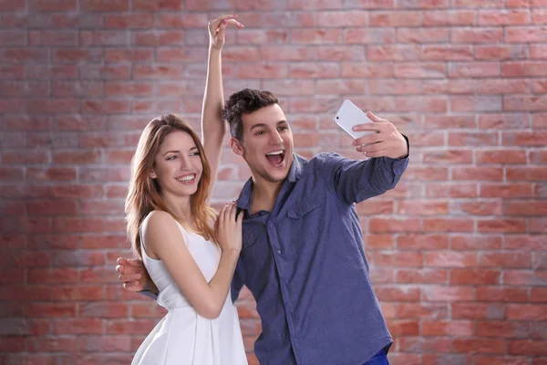 Mladý Atraktivní Pár Selfie Mobilním Telefonem Ujímá Cihlová Zeď Pozadí — Stock fotografie