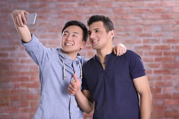 Dwóch Młodych Chłopców Biorąc Selfie Telefonu Komórkowego Tle Ściany Cegła — Zdjęcie stockowe
