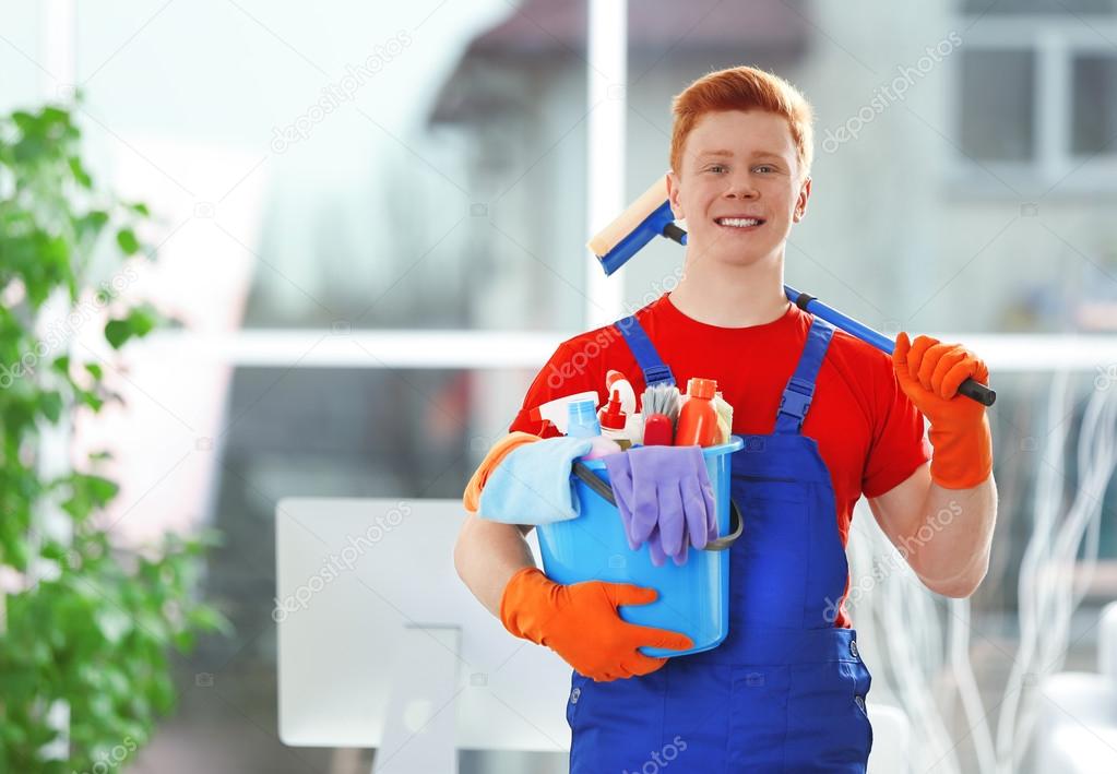 Young janitor holding cleaning products — Stock Photo © belchonock