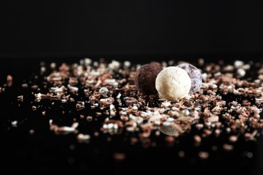 Siyah arka plan üzerine pul ile çeşitli çikolata şekerleme