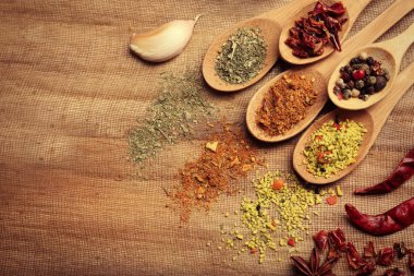 Ahşap masa, üstten görünüm üzerinde kaşık içinde çeşitli baharatlar