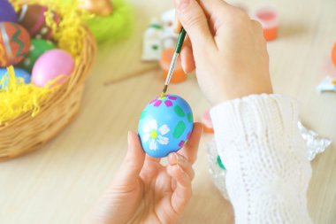 Paskalya yumurtalarını boyayan kadın eller 