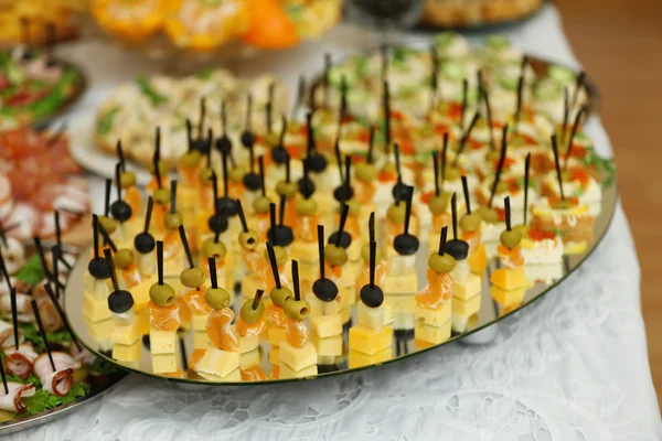 Plato con aperitivos surtidos en una mesa — Foto de Stock