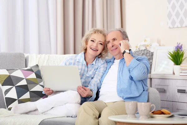 Ouder paar met laptop en mobiel — Stockfoto