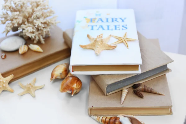 Books and seashells on the table — Stock Photo, Image