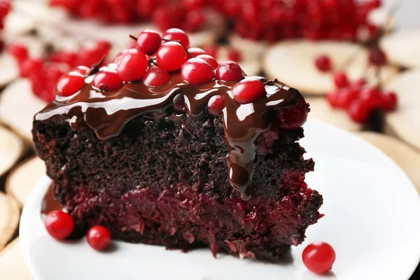 Pezzo di torta al cioccolato con mirtilli rossi su sfondo di legno, primo piano — Foto Stock